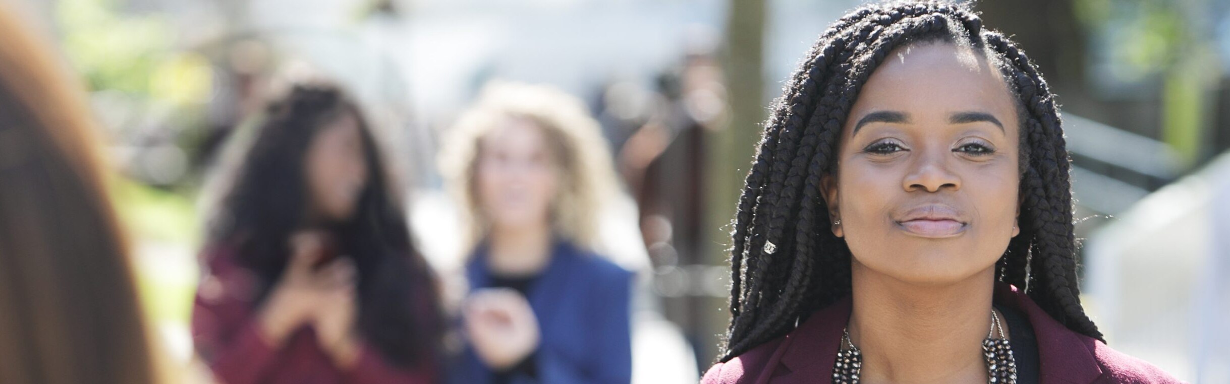 A woman with braids smiling to camera