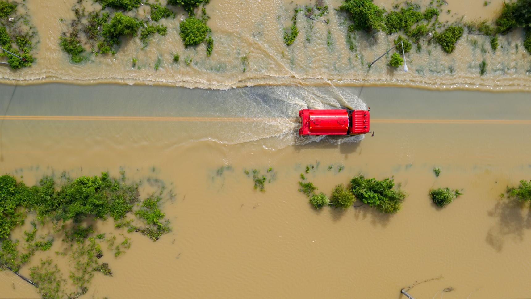 Aerial view of a truck driving through flooded farm land