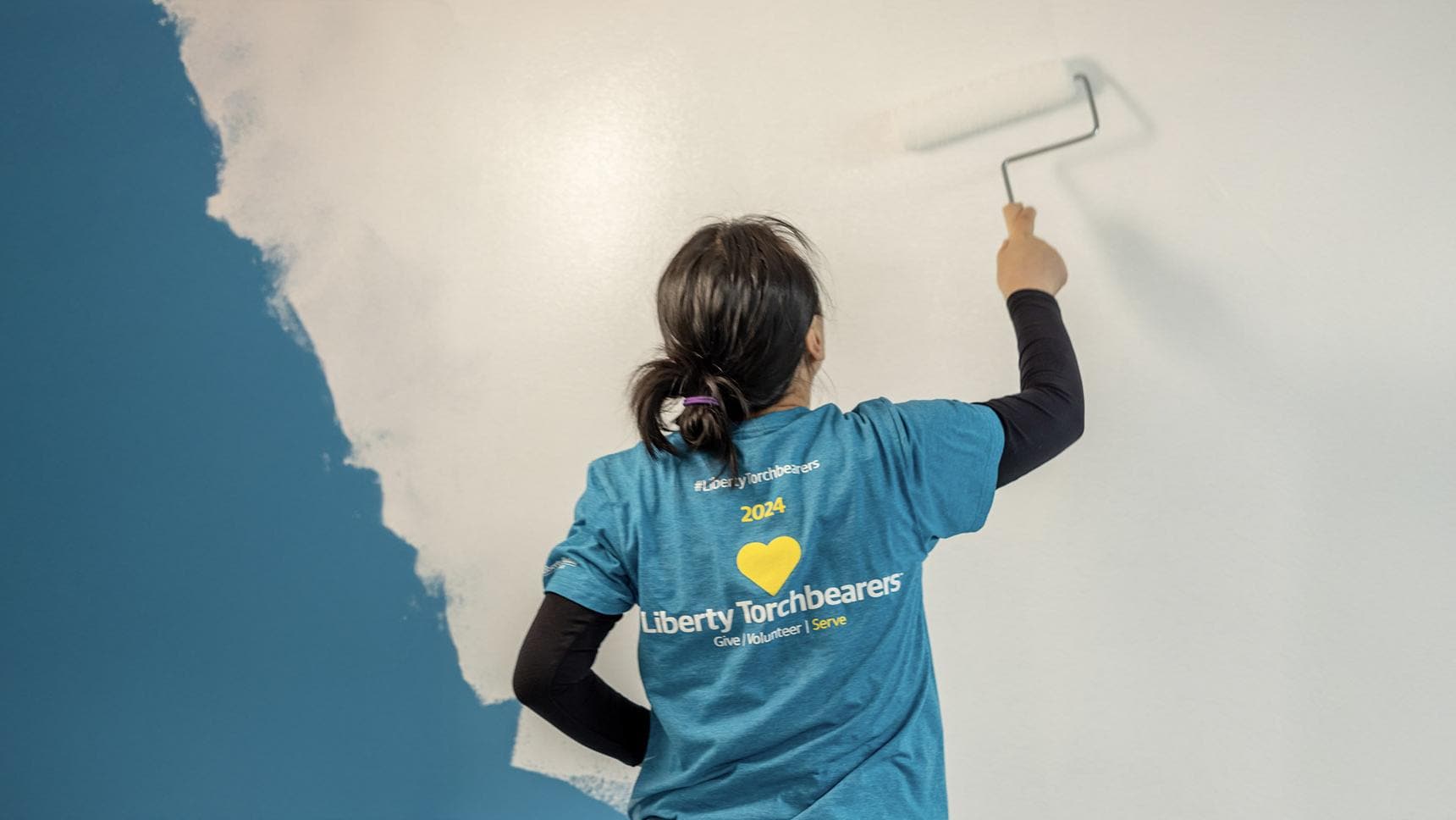 Serve with Liberty Volunteer painting a wall