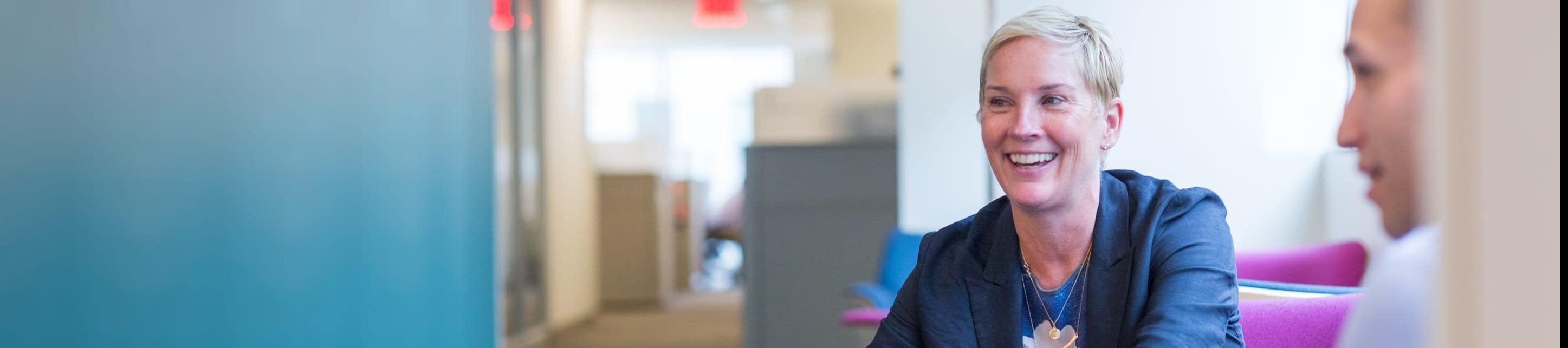 Coworkers laugh and talk in a collaborative space